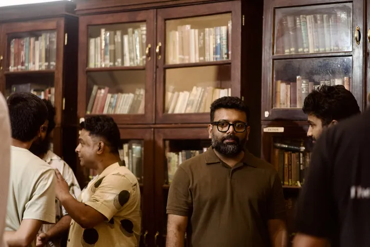 Coffee conversations beside the cupping table and wooden bookshelves at Cochin Club.