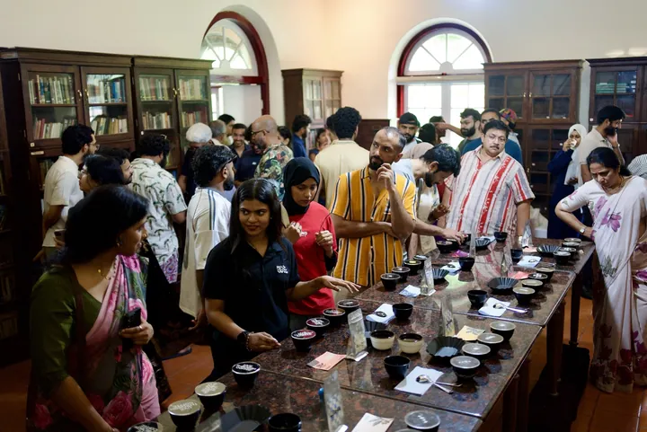 Guests around both sides of the coffee cupping table at Kerala Origins Kochi.