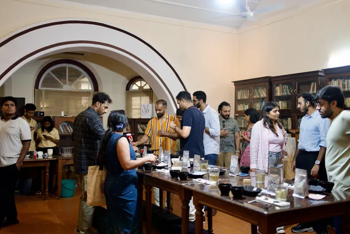 Coffee conversations around the long tasting table beneath the arches of Cochin Club.